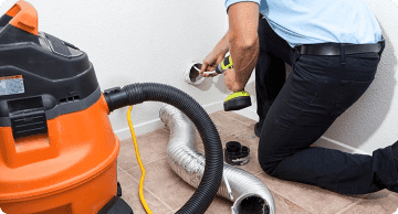 Technician cleaning the dryer vent in a residential home.