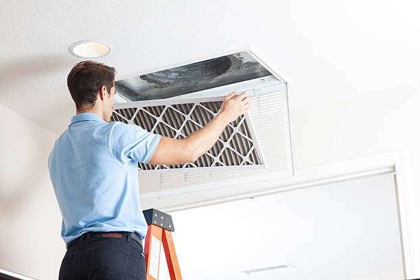 Technician cleaning air ducts in a residential setting
